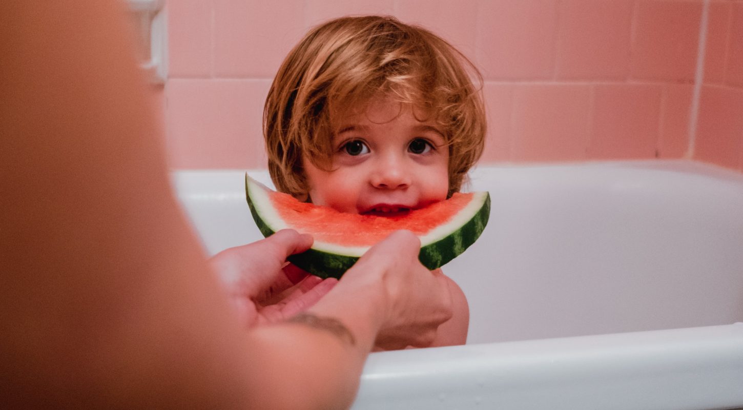 kid eating watermelon in tub